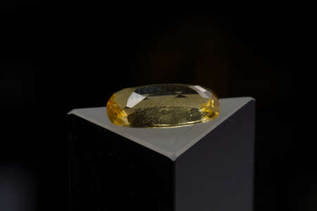 Natural gemstone yellow citrine on a black background