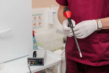 Anoscopes with ring lights in the hands of a doctor