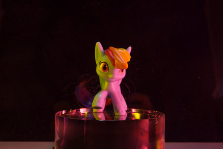 colorfull toy pony horse on the glass cylinder the color background