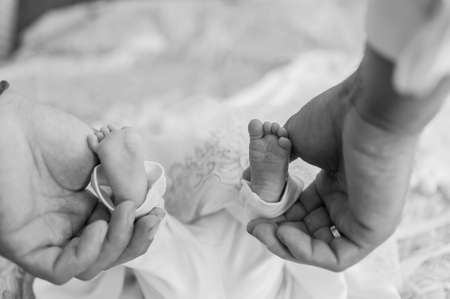 little baby feet baby on fathers armの写真素材