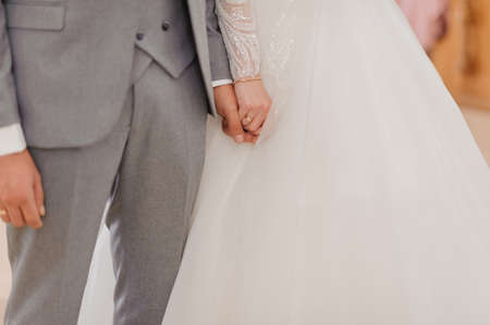 The groom holds the brides hand. The guy holds the girls handの写真素材