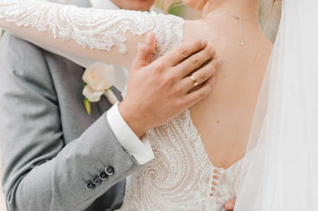 The groom holds the brides hand. The guy holds the girls handの写真素材