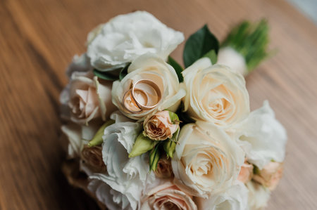 Wedding bouquet of fresh flowers, a pair of gold rings close-up. Wedding detailsの写真素材