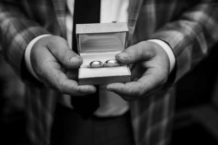 Wedding gold rings in the hands of the groom. Wedding details