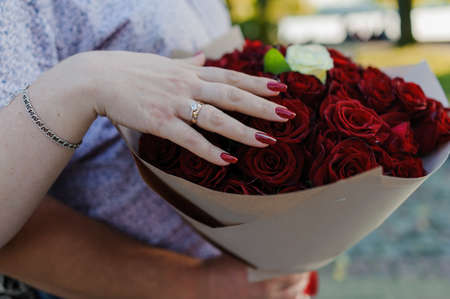 Bouquet of red roses, womens gold ring with a stone. Bouquet of red flowers. An offer of marriageの写真素材