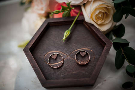 Beautiful bridal bouquet, a pair of golden wedding rings in a wooden box