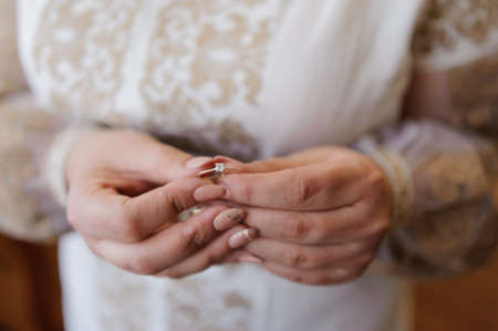 A pair of wedding gold rings in the hands of the bride. Wedding rings on a female handの写真素材