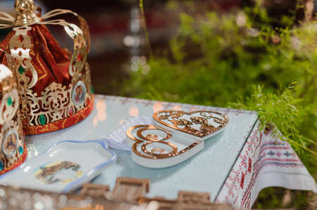 A pair of gold wedding rings on a heart-shaped standの写真素材