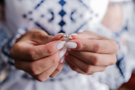 Gold ring with a stone in the hands of the brideの写真素材