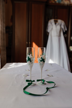 Wedding champagne glasses with decor. wedding bride dress in the backgroundの写真素材