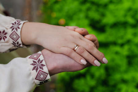 The groom holds the bride's hand. The guy holds the girl's hand. Weddingの写真素材