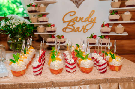 Sweet cakes in cups at a wedding buffet. candy barの写真素材