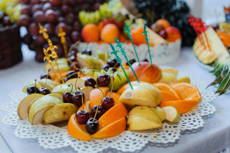 Fruit slicing at a wedding banquet. Watermelon, grapes, strawberry, orange, plum, pear, dinya peach...