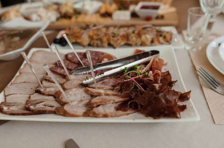 Slicing different types of meat. Meat snacks on the table. wedding buffetの写真素材