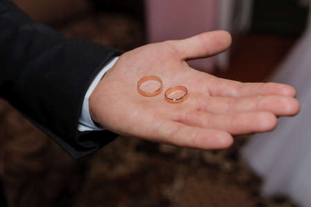 Wedding rings in the hands of the groomの写真素材