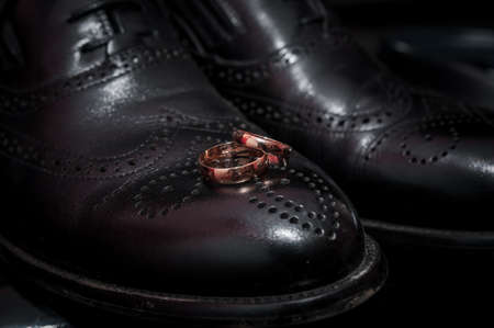 Pair of wedding rings on leather shoesの写真素材
