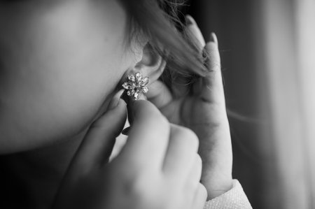 Woman fastening an earringの写真素材
