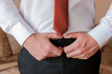 A man holding his hands on his belt