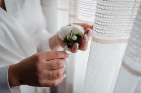 Boutonniere of the groom with flowers in the hands of the bride