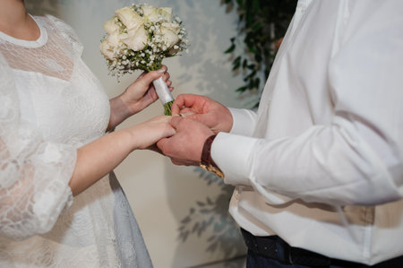 The bride and groom put on each other's wedding rings.