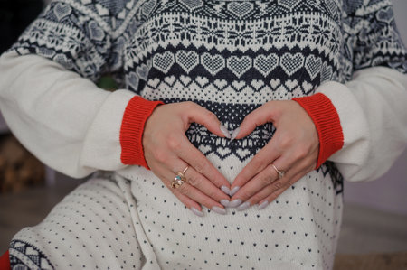 Pregnant woman holding her hands on her belly