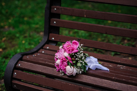 Two gold wedding rings on a bouquet of pink peoniesの写真素材