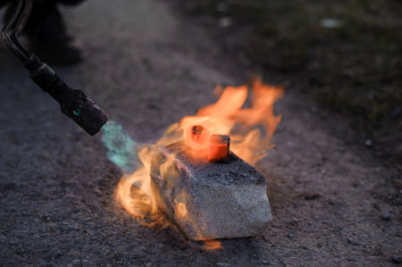 Coal on fire. Ignition of square coal with a gas burner on a stoneの写真素材