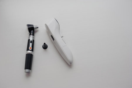 Non-contact thermometer on a white background for measuring body temperature. Otoscope on a background, a device for examining the auricle and middle earの写真素材