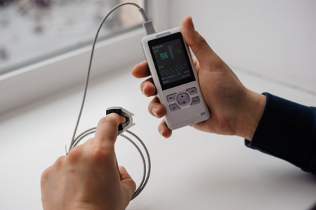 Man using finger pulse oximeter, healthcare monitoring concept. Pulse oximeter on a backgroundの写真素材