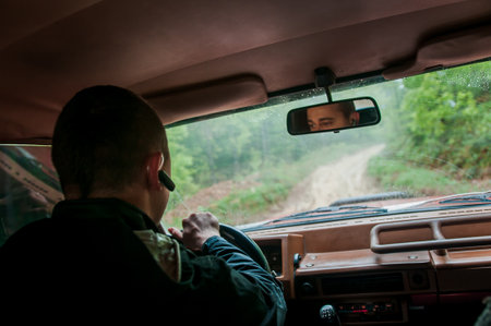 A man in a jacket driving a car in the mountainsの写真素材