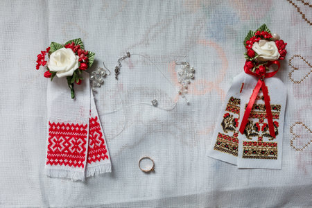 Wedding accessories on an embroidered towel, candles for church, boutonnieres for guests