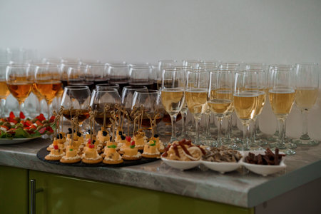 Festive buffet table. Glasses of white champagne, glasses of cognac, red wine. Canape with cheese and olives on a skewerの写真素材