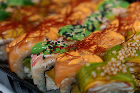 Rolls with red fish, rice, avocado, saffron. Set of rolls in a plate on a gray backgroundの写真素材