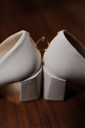 Ring with a stone on white women's leather shoes. Bride's accessories, bride's morning.の写真素材