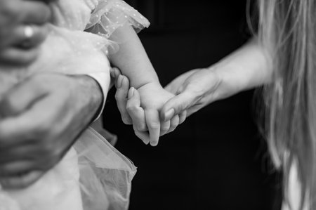 A woman holds a child's hand