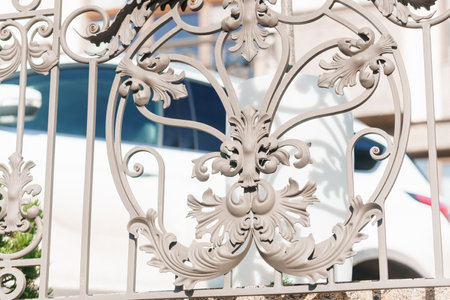 Image of a Beautiful decorative cast iron wrought fence with artistic forging. Metal guardrail close up.の写真素材