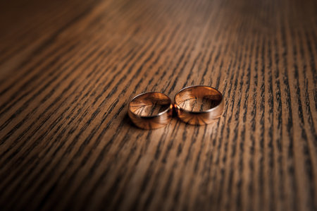 Two gold wedding rings on a brown background