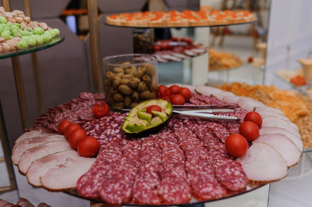 Slicing different types of meat. Meat snacks on the table. wedding buffet. Cateringの写真素材
