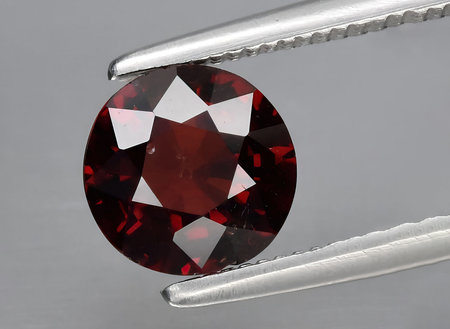 natural red spessartite garnet gem on background