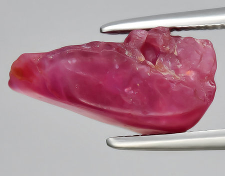natural red ruby rough gem on background