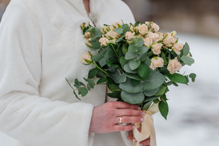 A beautiful wedding bouquet in the hands of the bride. A bouquet with white roses in the hands of the brideの写真素材