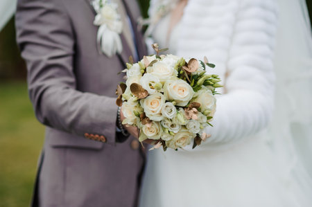 Bouquet with white roses in the hands of the groomの写真素材