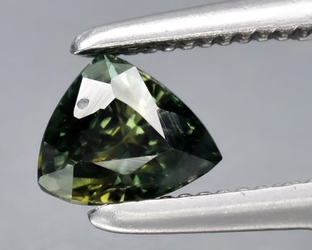 natural dark green sapphire gem on backgroundの写真素材