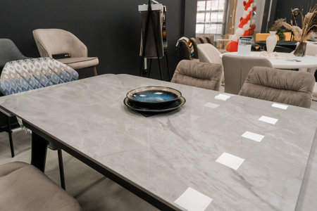 Gray wooden table combined with beige wooden chairs with soft fabric upholstery. Blue porcelain...