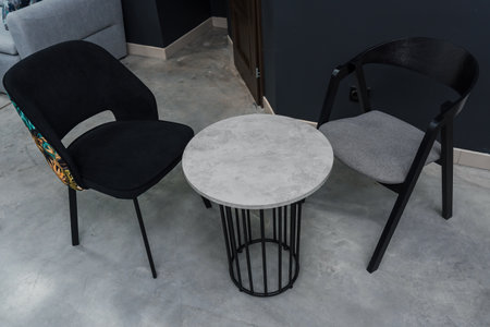 Gray wooden table combined with black wooden chairs with soft fabric upholstery