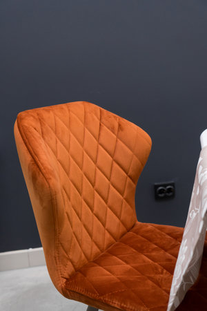 White wooden table combined with orange chairs with soft fabric upholstery. There is a white delivery with a multi-colored bouquet of flowers on the tableの写真素材