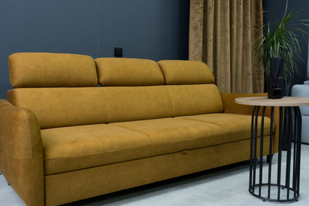 Yellow soft sofa in the interior against a black wallの写真素材