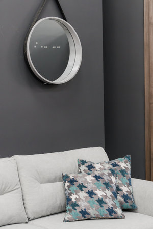 Gray soft sofa in the interior against a black wall