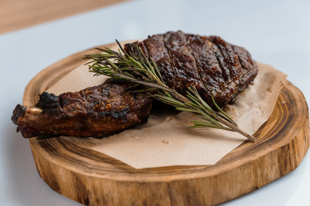 Pork steak with sauce on a wooden board on a white backgroundの写真素材