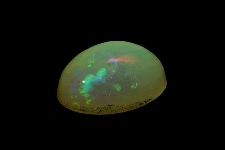 natural rainbow opal gem isolated on the black background
